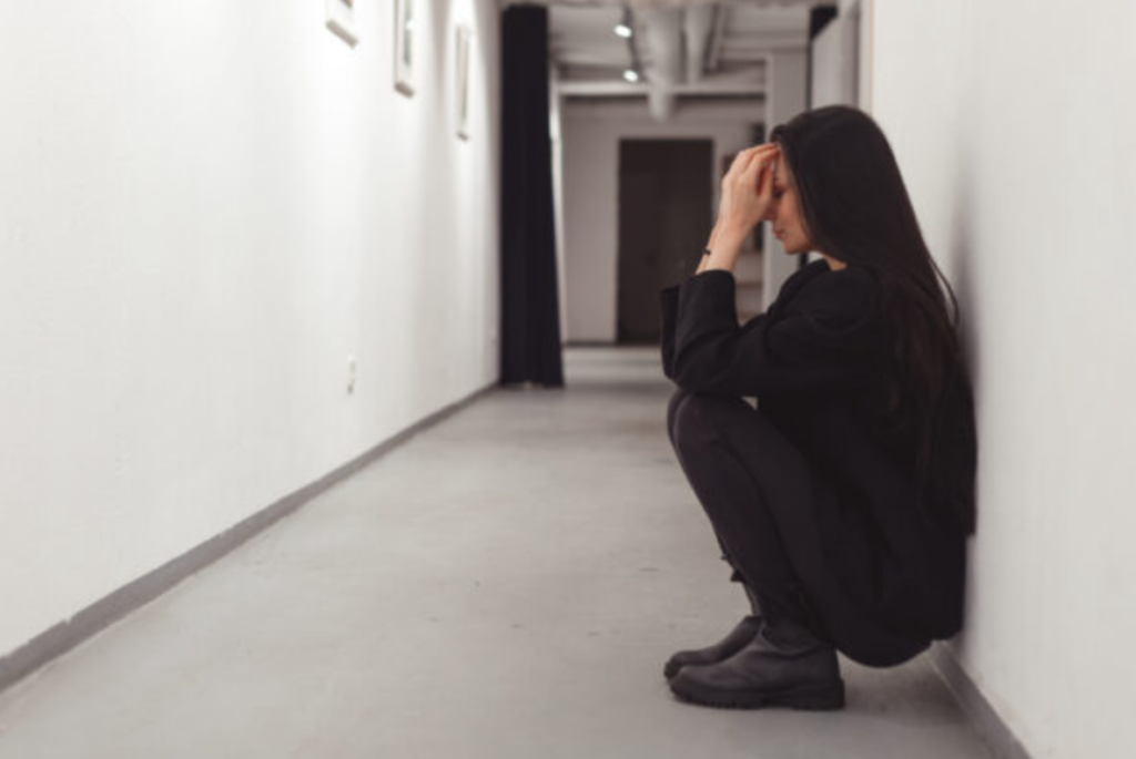 Stressed overworked young business woman sitting on floor. Fired and feeling depression in workplace of office.